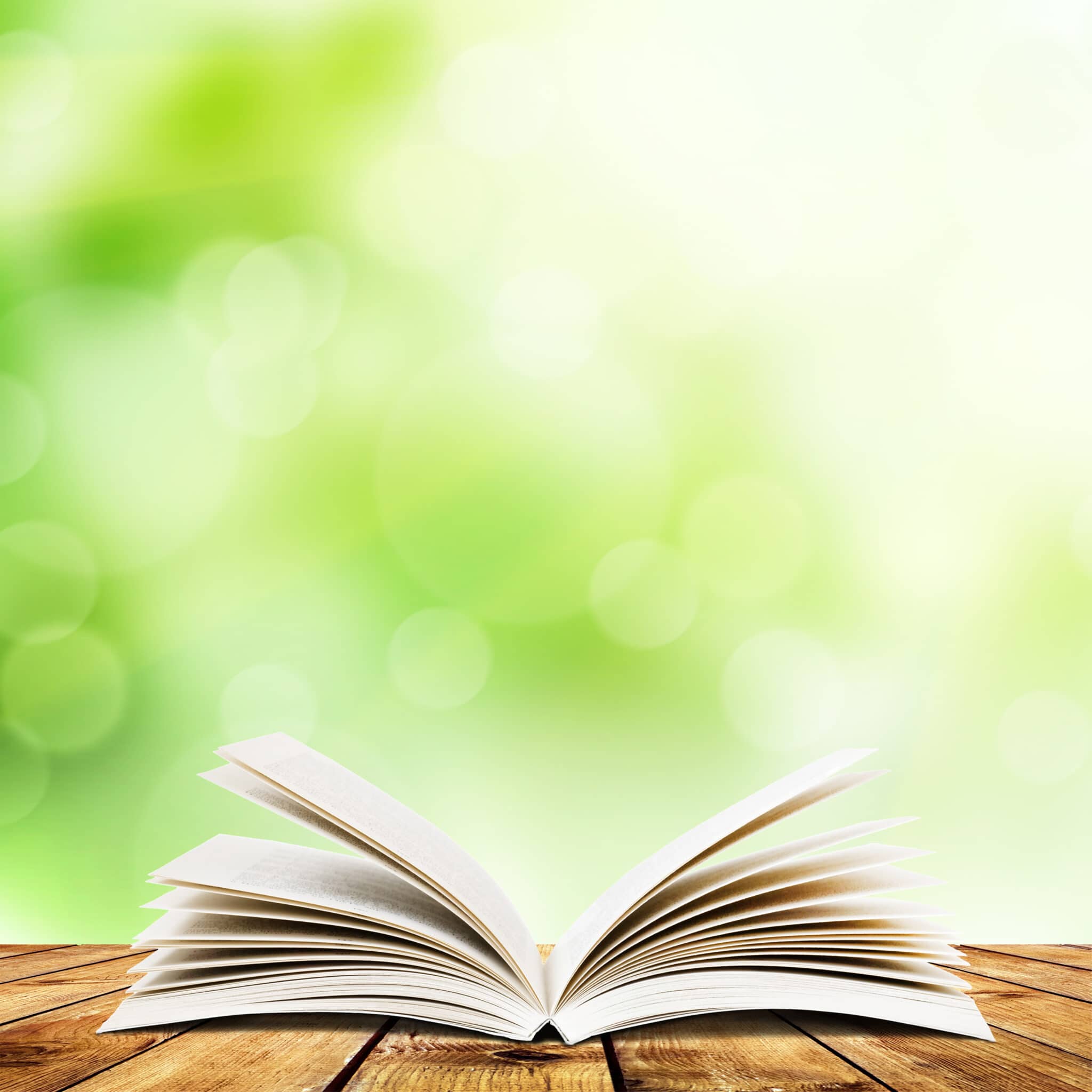 Open,Book,On,Wood,Planks,Over,Abstract,Light,Background